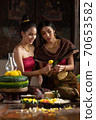 Two thai woman in traditional dress costume making and decorating Krathong. Loy Krathong Festival. 70653582