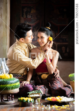 Thai couple in traditional dress costume making and decorating Krathong. Loy Krathong Festival. Thai couple in traditional dress costume making and decorating Krathong. Loy Krathong Festival. 70653588