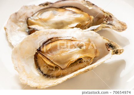 所謂的“微波牡蠣”是在微波爐中將其外殼附著在烤箱上加熱的。牡蠣的容易的烹調圖像與殼的。 70654974