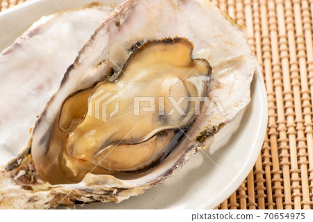 所謂的“微波牡蠣”是在微波爐中將其外殼附著在烤箱上加熱的。牡蠣的容易的烹調圖像與殼的。 70654975