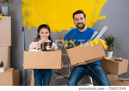 Little girl holding a big box with things. 70655549