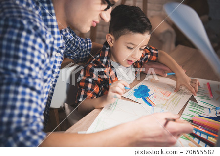 Little son with dad draws a picture at home. 70655582