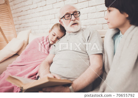 Grandfather with glasses looks at his grandson. Grandfather with glasses looks at his grandson. 70655792