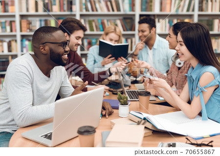 Students sit at a table and chatting together. Students sit at a table and chatting together. 70655867