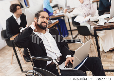 Disabled man in a suit sitting in the office. Disabled man in a suit sitting in the office. 70655884