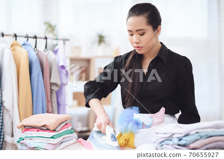 Asian woman looks at things and iron them. 70655927