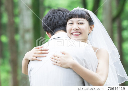 Bride and groom hugging Bride and groom hugging 70656419