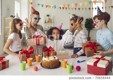 Happy African-American girl getting birthday presents from friends during fun party at home 70656444