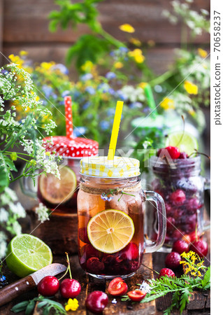 Healthy homemade cold lemonade with fresh berries and fruits in mason jar Healthy homemade cold lemonade with fresh berries and fruits in mason jar 70658237
