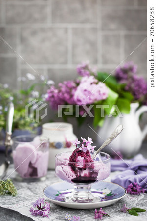 Cup of delicious homemade blueberry icecream and lilac on background Cup of delicious homemade blueberry icecream and lilac on background 70658238