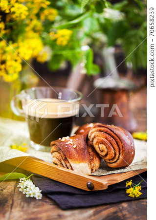 Homemade cinnamon and cardamom rolls (buns) and cup of black coffee Homemade cinnamon and cardamom rolls (buns) and cup of black coffee 70658239