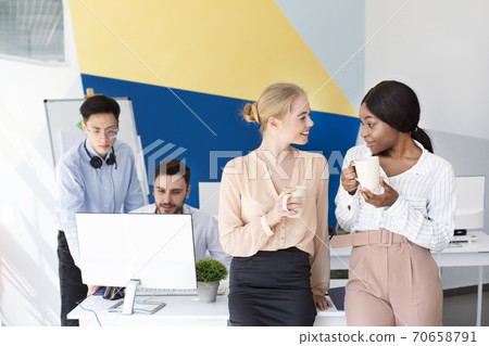 Female call centre operators having coffee and talking during their break at modern open space office, copy space 70658791