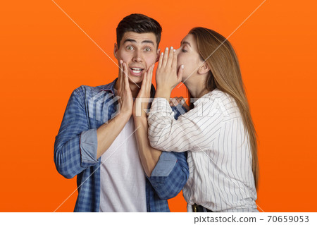 Millennial lady tells in ear to surprised guy something amazing, funny male do not believe it Millennial lady tells in ear to surprised guy something amazing, funny male do not believe it 70659053