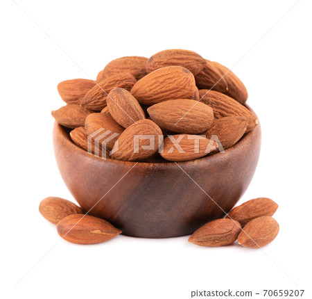 Almonds nuts in wooden bowl, isolated on white background. Pile of fried almond nuts. Top view. Almonds nuts in wooden bowl, isolated on white background. Pile of fried almond nuts. Top view. 70659207