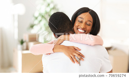Happy black lady holding house key and embracing her boyfriend in their apartment, copy space 70659274