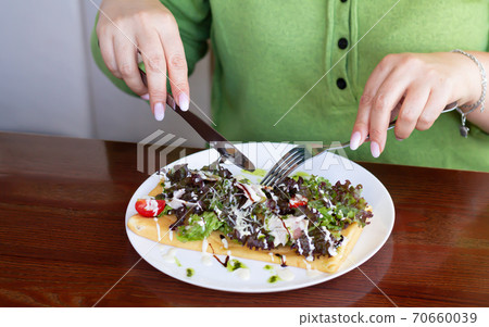 Woman have lunch in cafe. Female hands are holding cutlery 70660039