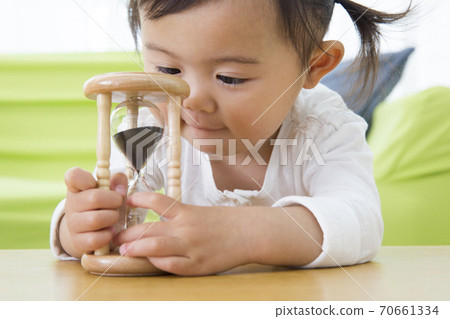 Toddler playing with an hourglass Toddler playing with an hourglass 70661334