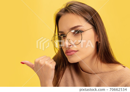 Portrait of young caucasian woman with bright emotions isolated on yellow studio background 70662534