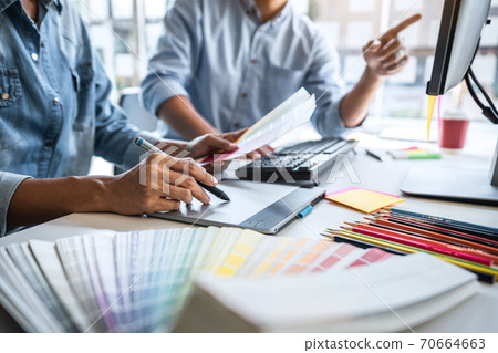 Young colleagues designers working together on a creative project and color samples for selection, Color swatch samples, Brainstorming Planning Partnership, creative graphic design working desktop 70664663