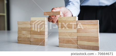 Plan and strategy in business, Risk To Make Business Growth Concept With Wooden Blocks, hand of man has piling up and stacking a wooden block 70664671