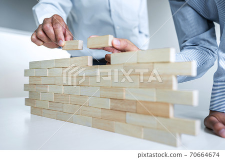 Plan and strategy in business, Risk To Make Business Growth Concept With Wooden Blocks, hand of man has piling up and stacking a wooden block Plan and strategy in business, Risk To Make Business Growth Concept With Wooden Blocks, hand of man has piling up and stacking a wooden block 70664674