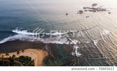 Aerial view of tropical landscape with palm trees, sandy beach, blue ocean at sunset. Sri Lanka Aerial view of tropical landscape with palm trees, sandy beach, blue ocean at sunset. Sri Lanka 70665621