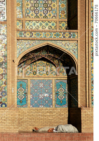 Herat in western Afghanistan. The Great Mosque of Herat (Friday Mosque or Jama Masjid). People resting in an alcove at the front of the mosque. The mosque is one of the oldest in Afghanistan. 70666178