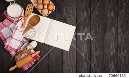 Recipe Cooking book, fresh Eggs, rolling pin, Flour and Wooden kitchen Utensils on dark rustic wooden background. 70666183