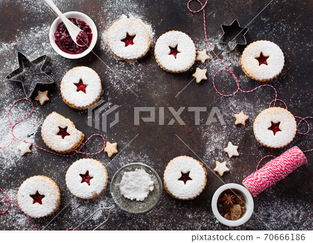Traditional Christmas Linzer cookies with raspberry jam on dark background. 70666186