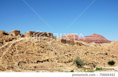 Village between Herat and Qala-e-Naw, Herat Province in Afghanistan with a backdrop of colorful red mountains in a very remote part of western Afghanistan. On the road from Herat to Bala Morgab. 70666482