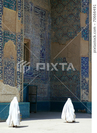 The Shrine of Khwaja Abu Nasr Parsa (Green Mosque) in Balkh, Afghanistan. The shrine is ornately decorated with mosaics and stylized quranic calligraphy. Unidentifiable women walk past. The Shrine of Khwaja Abu Nasr Parsa (Green Mosque) in Balkh, Afghanistan. The shrine is ornately decorated with mosaics and stylized quranic calligraphy. Unidentifiable women walk past. 70666491