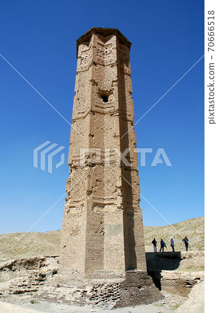 One of the two ancient minarets at Ghazni in Afghanistan with people for scale. The Ghazni Minarets are elaborately decorated with geometric patterns. The monuments are a famous symbol of Ghazni. One of the two ancient minarets at Ghazni in Afghanistan with people for scale. The Ghazni Minarets are elaborately decorated with geometric patterns. The monuments are a famous symbol of Ghazni. 70666518