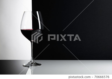 Glass of red wine on a reflexive background. 70666576
