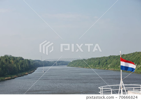 Cruise ship sailing through Kiel canal in Germany. The Kiel Canal goes through the middle of Schleswig-Holstein and it is 98 km long Cruise ship sailing through Kiel canal in Germany. The Kiel Canal goes through the middle of Schleswig-Holstein and it is 98 km long 70666824