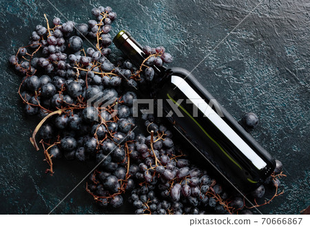 Bottle of red wine and grapes. 70666867
