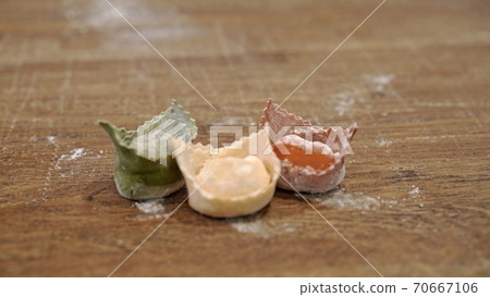 Three raw tortellini on wooden table, italian flag colours Three raw tortellini on wooden table, italian flag colours 70667106