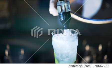 One mojito cocktail on bar counter, pouring soda into glass One mojito cocktail on bar counter, pouring soda into glass 70667282