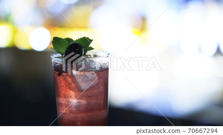 One blackberry cocktail shot on bar counter lens flare, bokeh effect 70667294