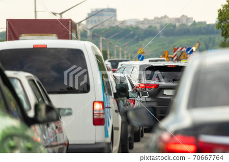 Highway interstate road with car traffic jam and Kiev on background. Motorway bumber barrier gridlock due country border control point. Vehicle crash accident and queue bottleneck on freeway 70667764