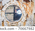 An old abandoned ship's porthole 70667982
