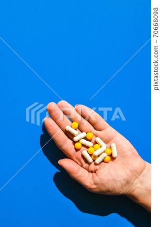 A handful of colored pills on the palm. Medical concept. Shopping at the pharmacy. Copy space A handful of colored pills on the palm. Medical concept. Shopping at the pharmacy. Copy space 70668098