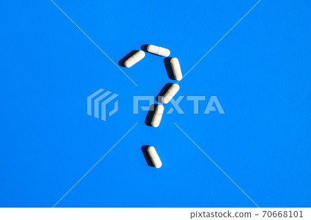Question mark made of white pills, tablets and capsules on blue background. Pharmaceutical industry, and prescription minimal concept. Copy space Question mark made of white pills, tablets and capsules on blue background. Pharmaceutical industry, and prescription minimal concept. Copy space 70668101