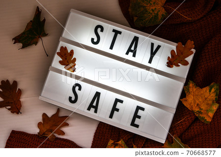 Stay safe. Text in white light box, with a background of sweater, dried leaves autumn decoration. Coronavirus devices. Social distancing. Protection against pandemics 70668577