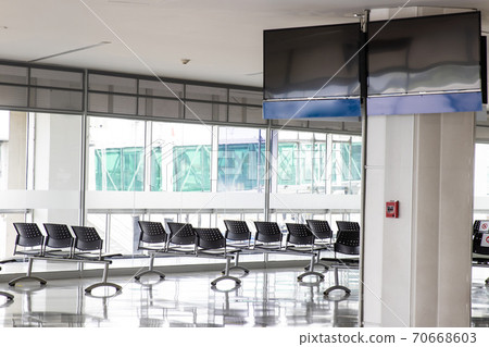 Empty waiting room at an airport during COVID-19 pandemic with social distancing signs on chairs Empty waiting room at an airport during COVID-19 pandemic with social distancing signs on chairs 70668603
