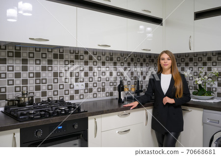 Young woman at luxury modern white kitchen interior in provence style Young woman at luxury modern white kitchen interior in provence style 70668681