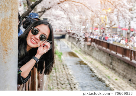 Young woman visiting Jinhae Gunhangje Cherry blossom Festival in South Korea. 70669833