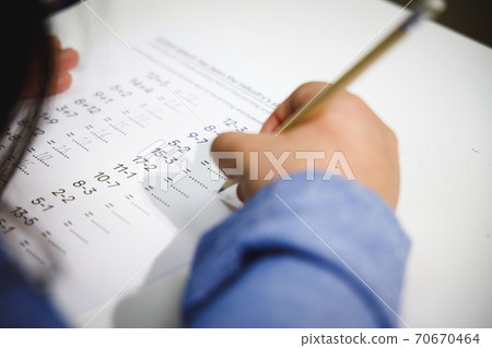 Close up mathematics homework of school children. Student doing quiz during math class. 70670464