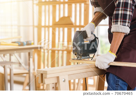 Man use jigsaw for woodwork in carpentry workshop. Man use jigsaw for woodwork in carpentry workshop. 70670465