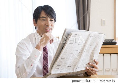 A man reading a newspaper 70670615