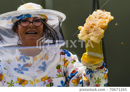Beekeeper Beekeeper holding honey comb Beekeeper Beekeeper holding honey comb 70671265